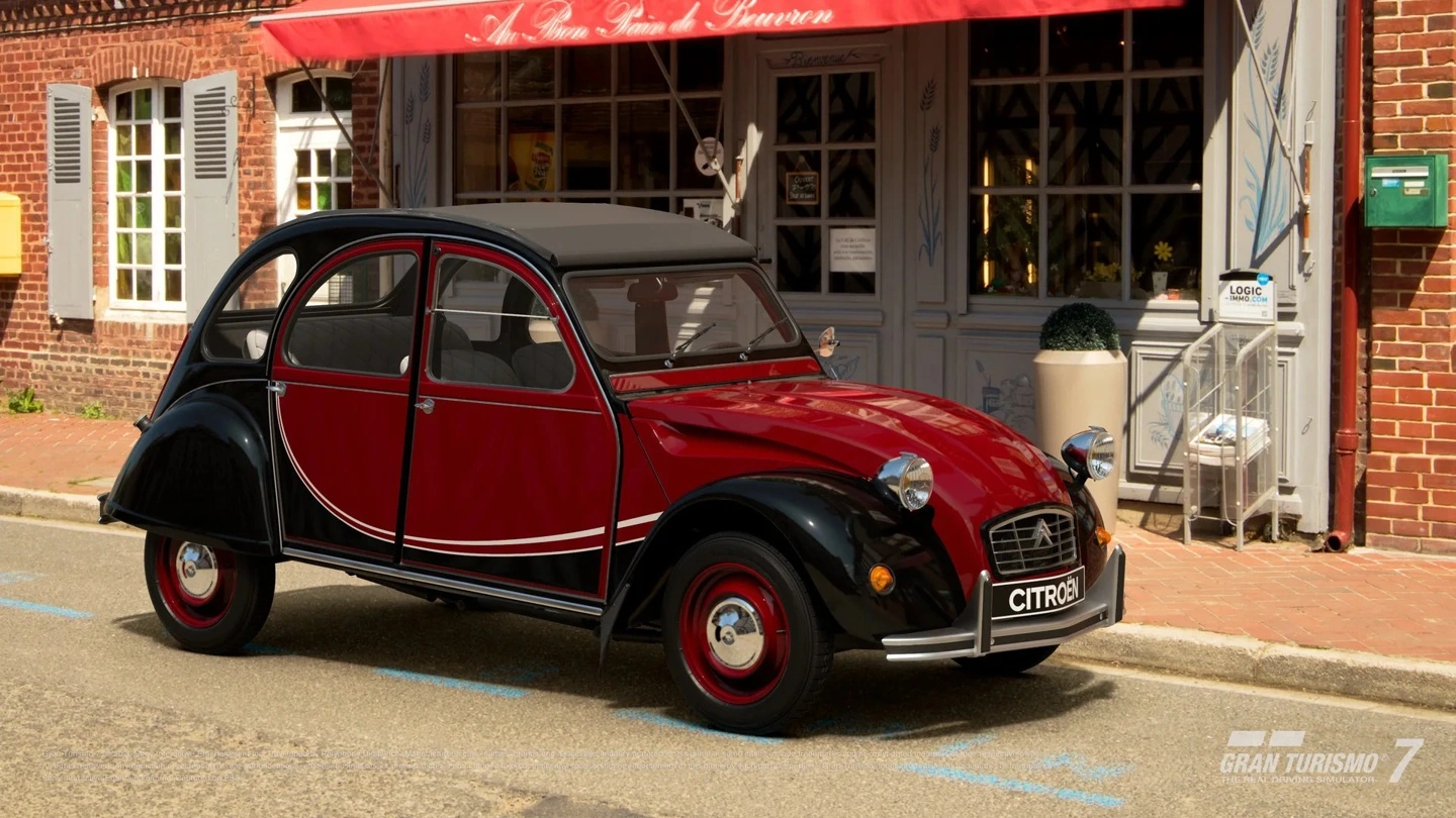 وحدة تحكم DualSense التذكارية بجوار سيارة Citroën 2 CV 6 Charleston موديل 1986 في Gran Turismo 7.